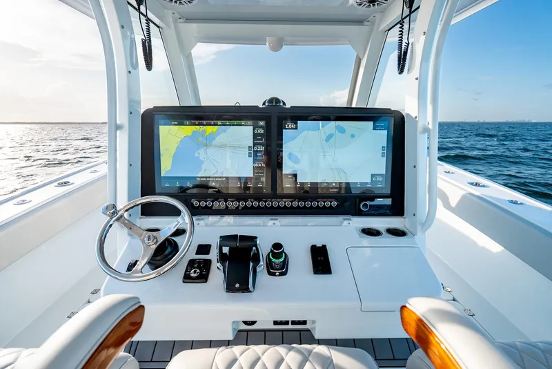 Slide: The Image of 2023 Freeman 43 boat helm with dual navigation screens on open water. - 18