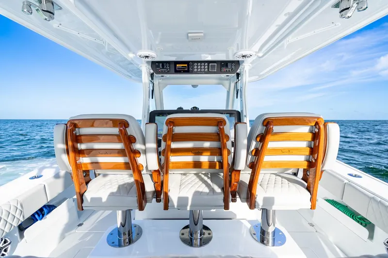 Slide: The Image of Interior of 2023 Freeman 43 boat with three wooden seats overlooking the ocean. - 23