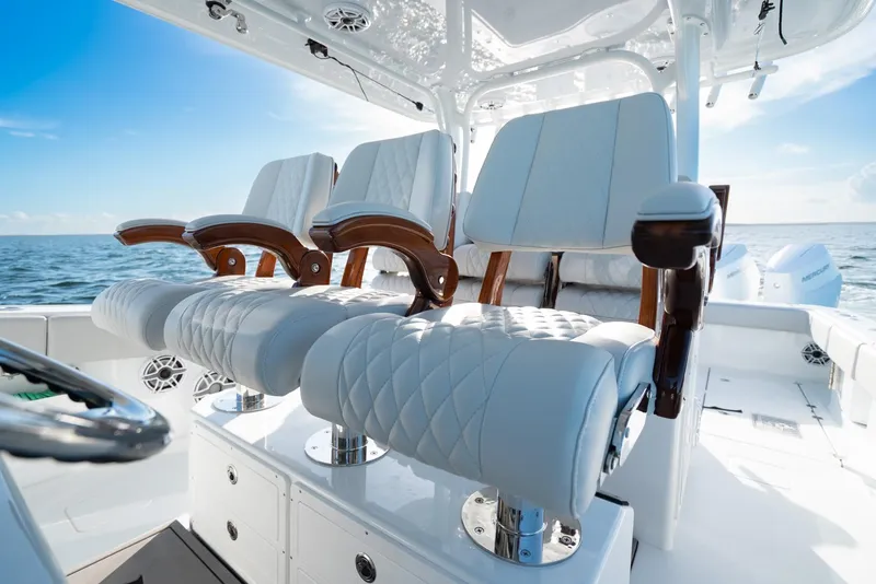 Slide: The Image of Luxurious seating on a 2023 Freeman 43 boat, featuring elegant white upholstery and wooden armrests. - 27