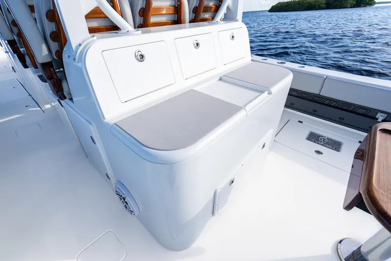 Slide: The Image of 2023 Freeman 43 boat interior with cushioned seating and storage compartments, on calm water. - 31