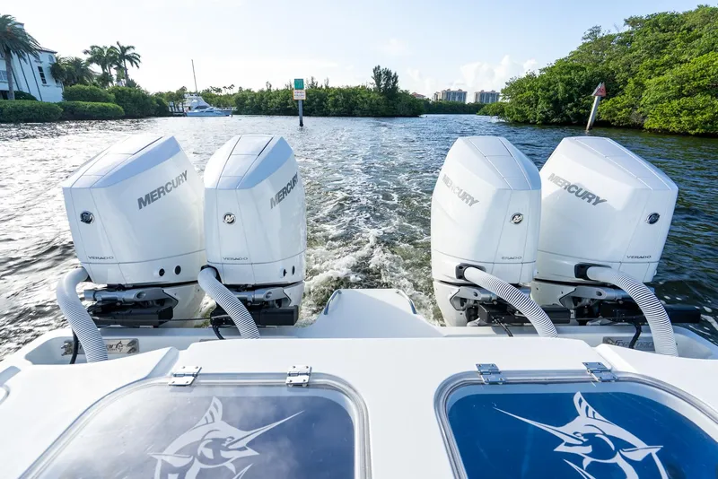 Slide: The Image of Four Mercury Verado outboard engines on a 2023 Freeman 43 boat, cruising through a scenic waterway. - 46