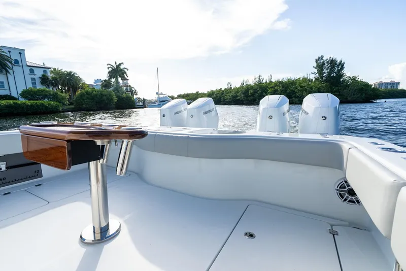 Slide: The Image of 2023 Freeman 43 boat with Mercury engines, docked near lush greenery and waterfront homes. - 48