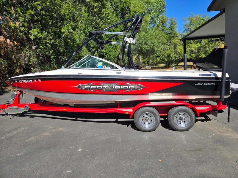 Slide: The Image of 2009 Centurion Air Warrior Elite V-Drive C4 boat on a red trailer, parked outdoors. - 17