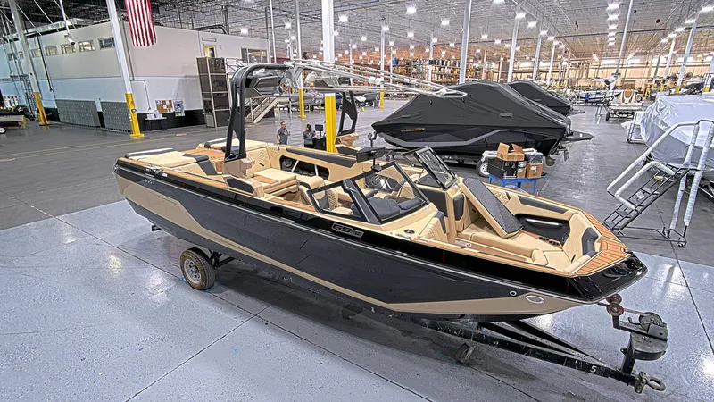 The Image of 2025 Nautique GS24 boat in a factory setting, showcasing sleek design and modern features. - 1