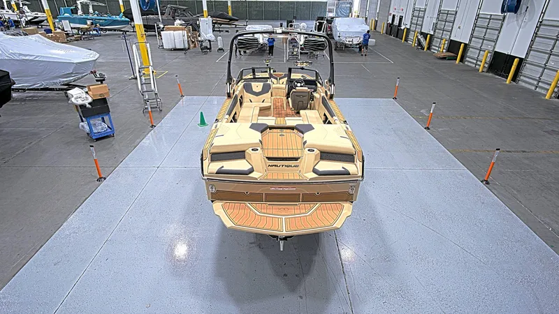 Slide: The Image of 2025 Nautique GS24 boat in a spacious indoor facility, showcasing its sleek design. - 6