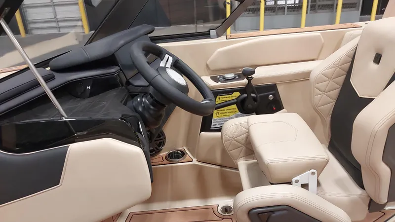Slide: The Image of 2025 Nautique GS24 boat interior with beige leather seats and modern steering console. - 9