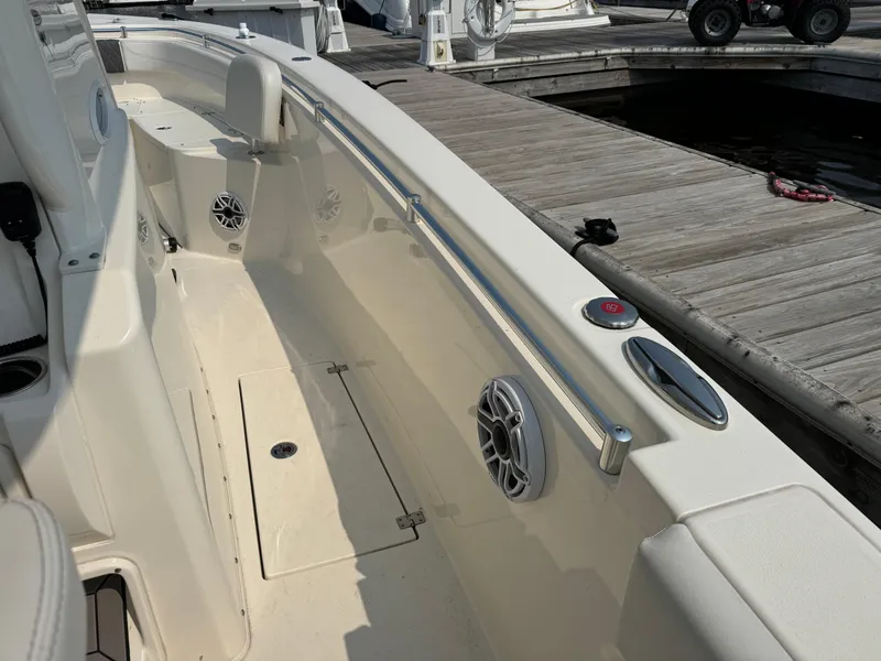 Slide: The Image of 2023 Cobia 301 CC boat interior with speakers and dock view. - 12
