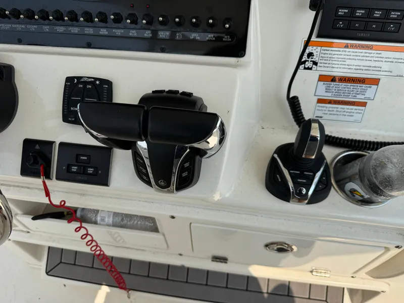 Slide: The Image of Control panel of 2023 Cobia 301 CC boat with throttle and joystick controls. - 15