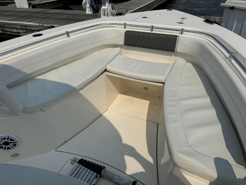 Slide: The Image of 2023 Cobia 301 CC boat interior with white cushioned seating and sleek design. - 18