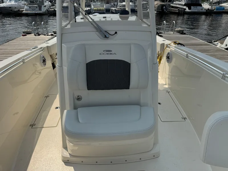Slide: The Image of 2023 Cobia 301 CC boat interior with seating, docked at marina. - 19