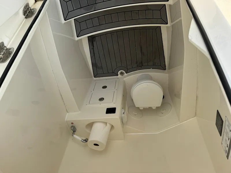 Slide: The Image of 2023 Cobia 301 CC boat interior with toilet and storage compartments. - 20