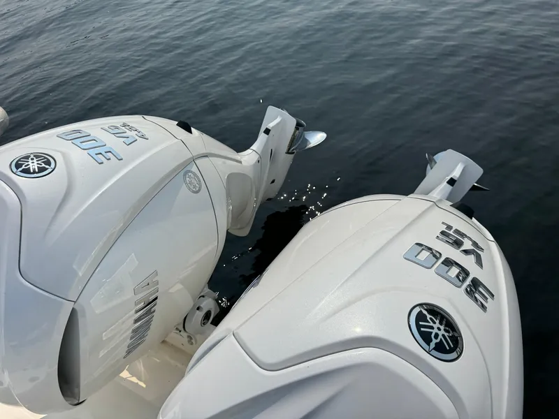 Slide: The Image of Twin Yamaha outboard engines on a 2023 Cobia 301 CC boat, floating on water. - 22