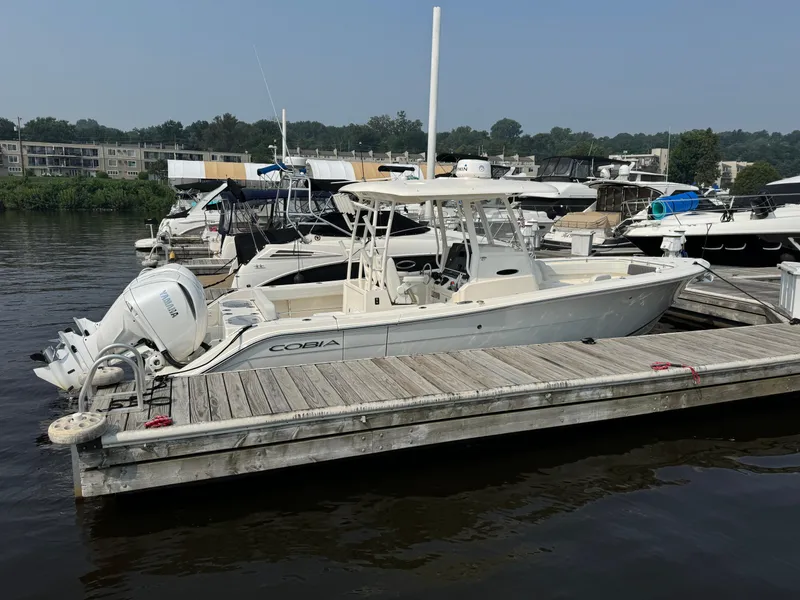 Slide: The Image of 2023 Cobia 301 CC boat docked at marina with Yamaha engines. - 6