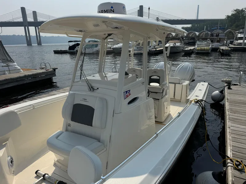 Slide: The Image of 2023 Cobia 301 CC boat docked near a bridge, featuring a sleek design and modern equipment. - 9