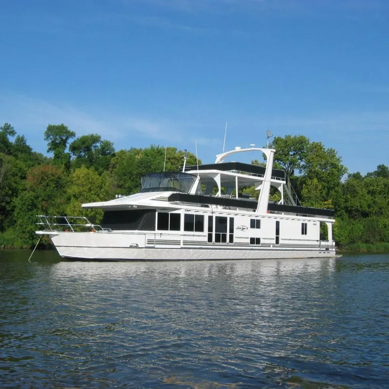 The Image of Majestic 90 X 18 yacht from 2004 on a serene lake with lush greenery. - 0