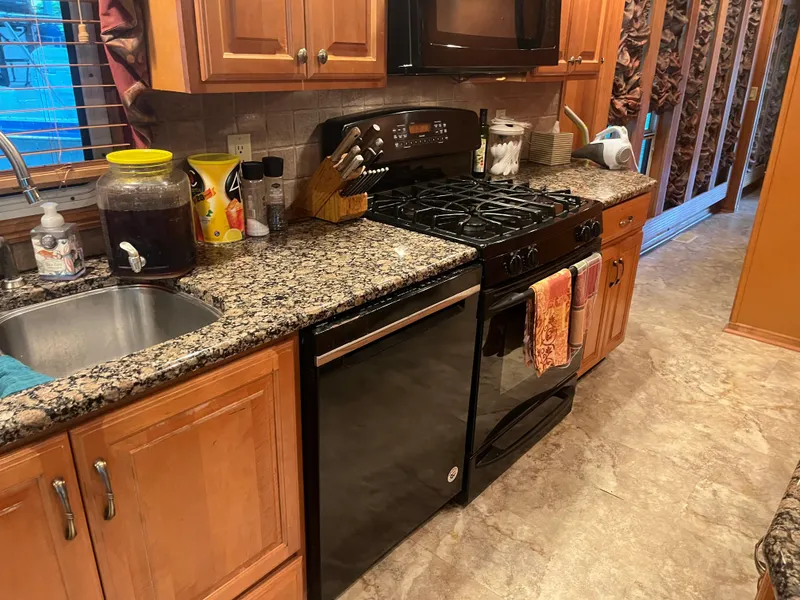 Slide: The Image of Modern kitchen with granite countertops, wooden cabinets, and a Majestic 90 X 18 stove. - 19