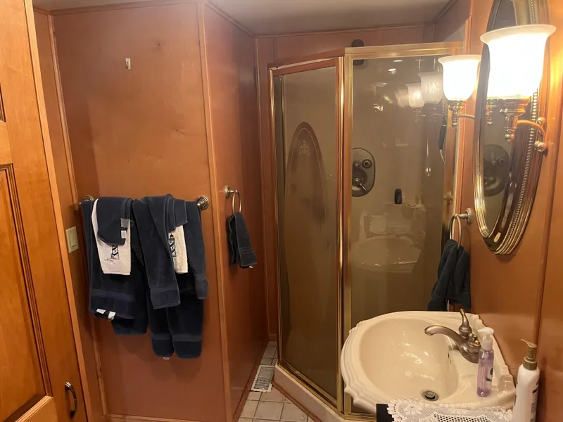 Slide: The Image of Luxurious bathroom with wooden paneling, glass shower, and elegant lighting in a 2003 Majestic 90 X 18. - 31