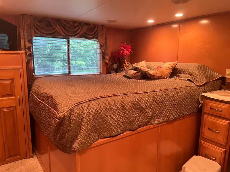 Slide: The Image of Cozy bedroom interior in Majestic 90 X 18, 2003 model, with elegant bedding and wooden cabinetry. - 33