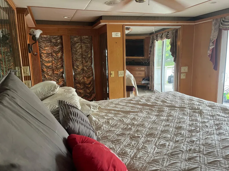 Slide: The Image of Luxurious bedroom interior in a 2003 Majestic 90 X 18 houseboat, featuring elegant decor and large windows. - 38