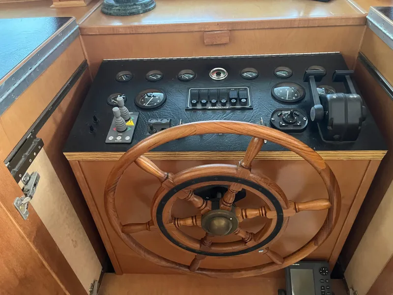 Slide: The Image of Wooden ship steering wheel and control panel of a 2003 Majestic 90 X 18 boat. - 9