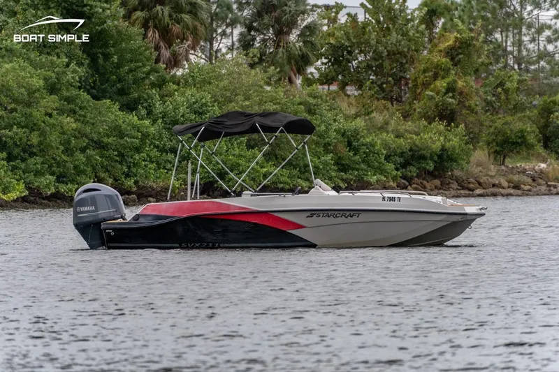 Slide: The Image of 2022 Starcraft SVX 211 OB boat on a calm river with lush greenery. - 1