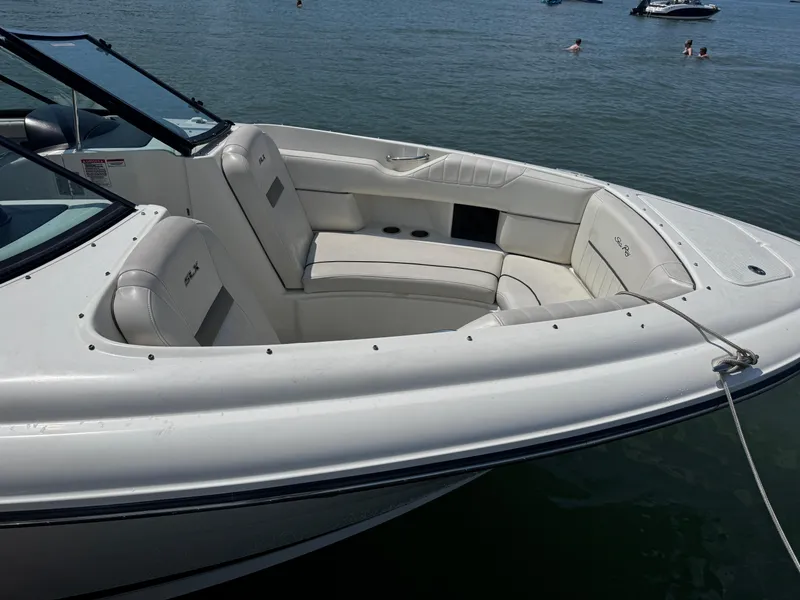 Slide: The Image of 2007 Sea Ray 270 SLX boat with white seating, docked on calm water. - 5