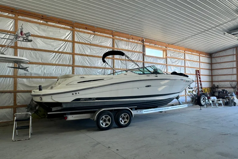 Slide: The Image of 2007 Sea Ray 270 SLX boat on trailer in spacious indoor storage facility. - 1