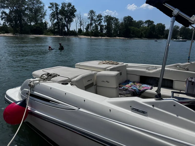 Slide: The Image of 2007 Sea Ray 270 SLX boat on calm water near a wooded shoreline. - 3