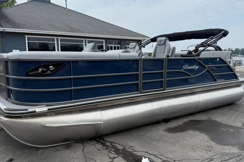 Slide: The Image of 2026 Bentley Pontoons 223 Quad Swingback, blue pontoon boat, docked near a building. - 1