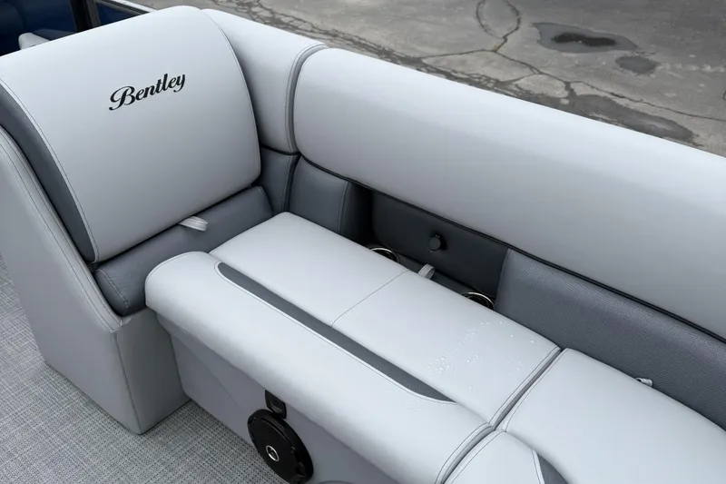 Slide: The Image of 2026 Bentley Pontoons 223 Quad Swingback interior with luxurious gray seating and logo. - 17