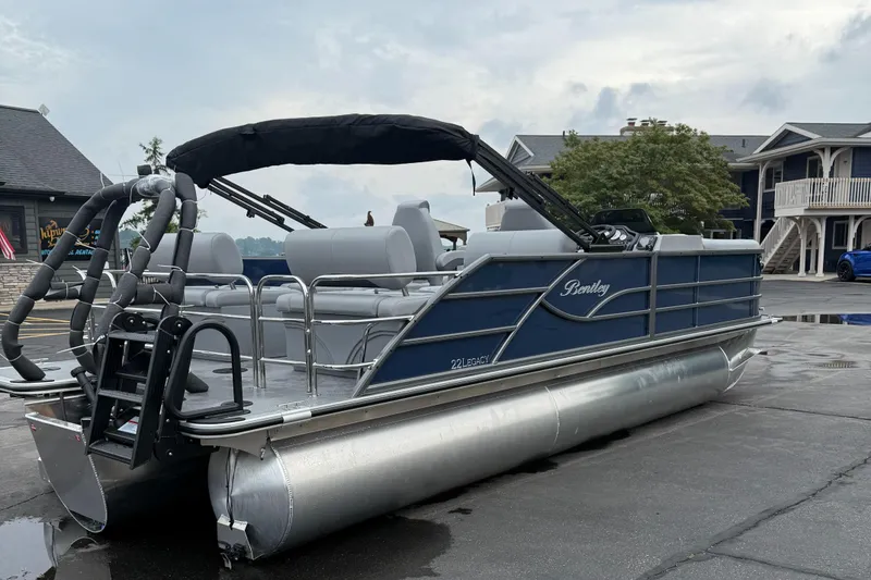 Slide: The Image of 2026 Bentley Pontoons 223 Quad Swingback, sleek design, parked outdoors on a wet surface. - 2