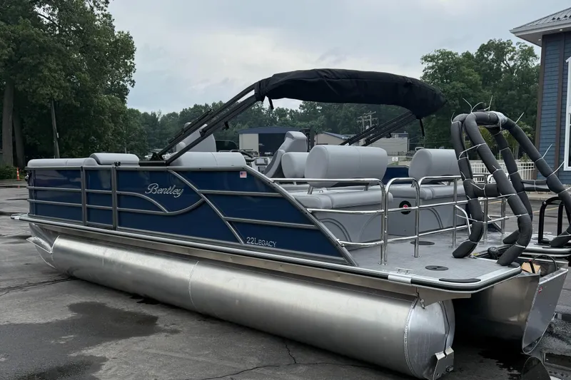 Slide: The Image of 2026 Bentley Pontoons 223 Quad Swingback, blue pontoon boat with canopy, parked outdoors. - 4