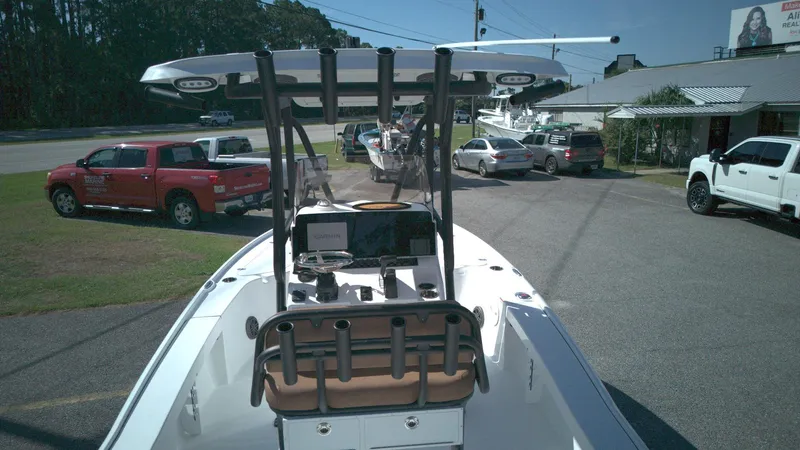 Slide: The Image of 2026 Sea Hunt BX22BR boat with T-top, parked near vehicles and a building. - 8