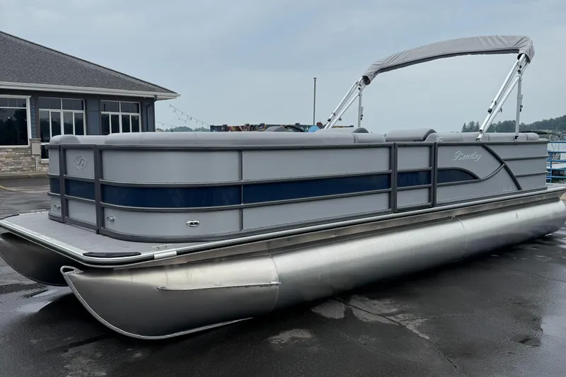 The Image of 2026 Bentley Pontoons Legacy 240 Cruise XL on wet pavement near a building. - 0