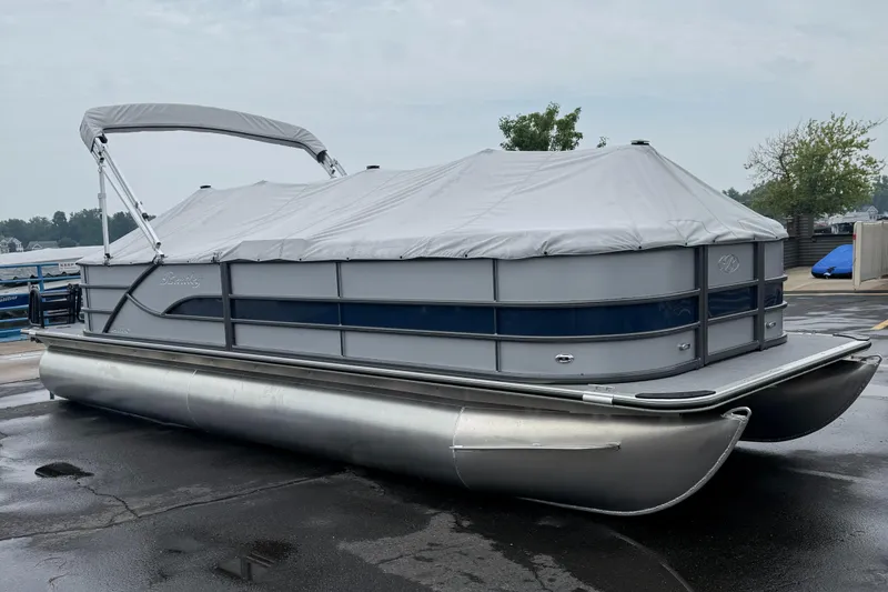 Slide: The Image of 2026 Bentley Pontoons Legacy 240 Cruise XL pontoon boat with cover, parked on wet pavement. - 6