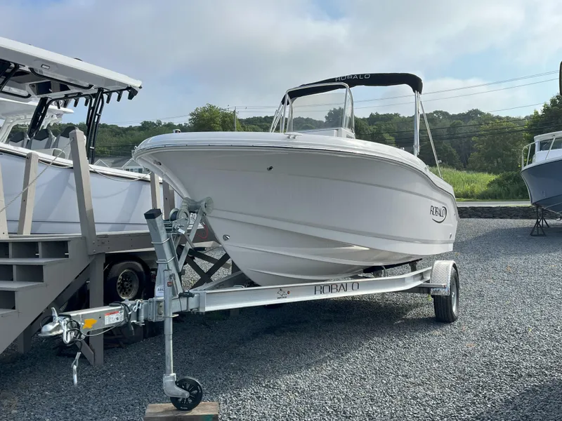 The Image of 2025 Robalo R180 Center Console boat on trailer, parked outdoors. - 0