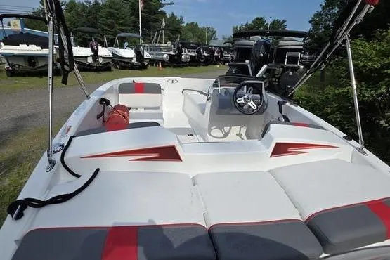Slide: The Image of 2023 Tahoe T16 boat with red accents, steering console, and seating, displayed outdoors. - 16