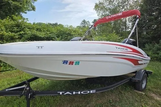 Slide: The Image of 2023 Tahoe T16 boat on trailer, white with red accents, parked on grass. - 4