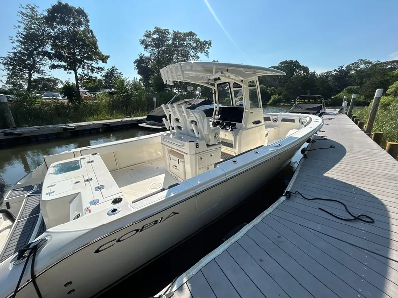 Slide: The Image of 2026 Cobia 285 Center Console boat docked, showcasing sleek design and spacious deck. - 1
