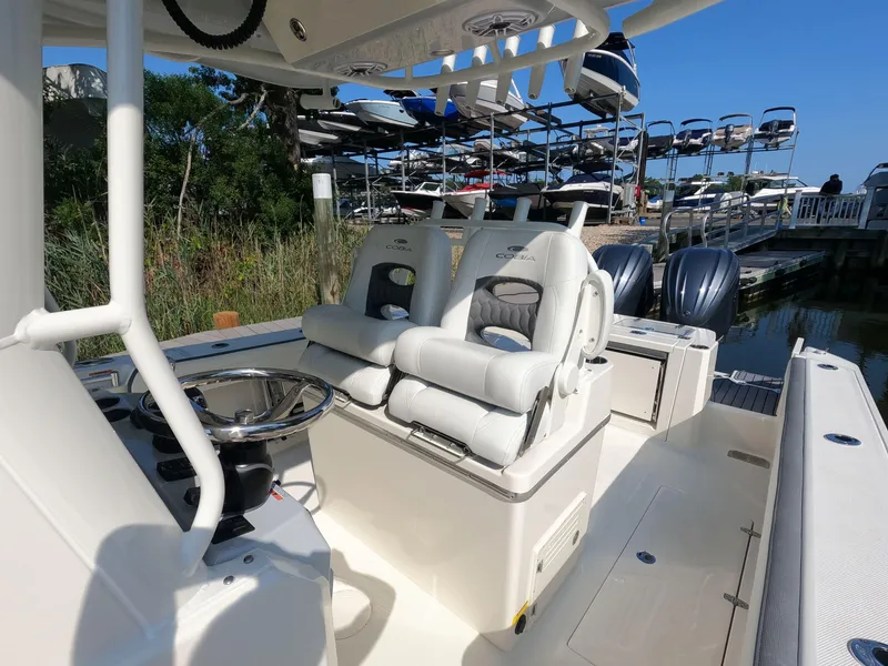 Slide: The Image of 2026 Cobia 285 Center Console boat interior with dual seats and steering wheel. - 11
