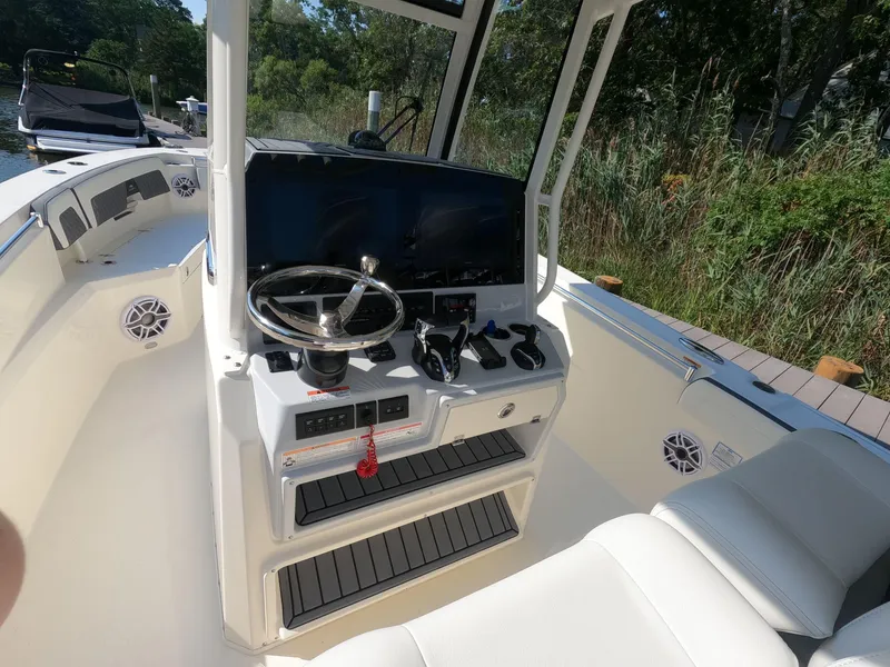 Slide: The Image of 2026 Cobia 285 Center Console boat interior with steering wheel and control panel. - 14