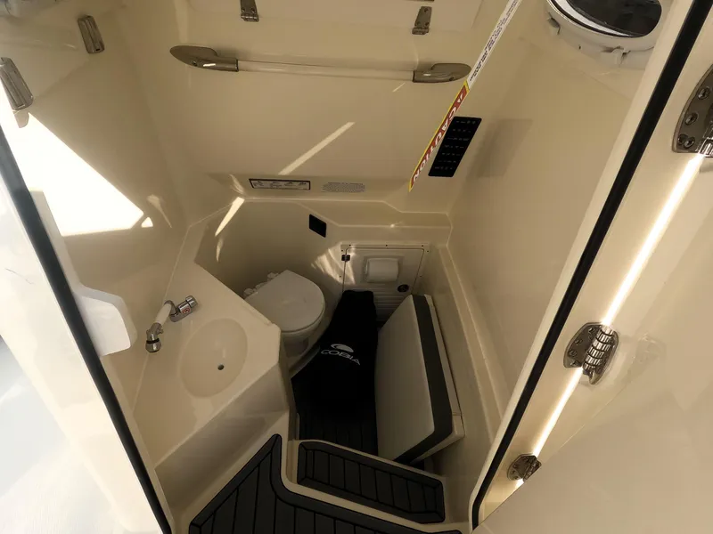 Slide: The Image of Interior of 2026 Cobia 285 Center Console boat featuring compact bathroom amenities. - 22