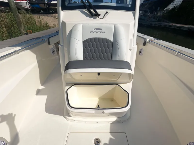 Slide: The Image of 2026 Cobia 285 Center Console boat with open storage compartment and cushioned seating. - 24