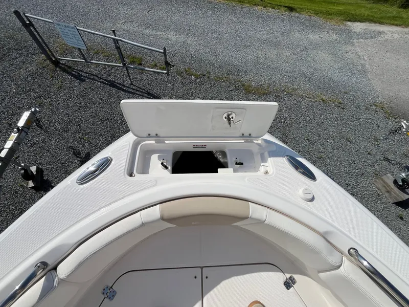 Slide: The Image of 2025 Robalo R222 Center Console boat with open storage compartment on deck. - 8