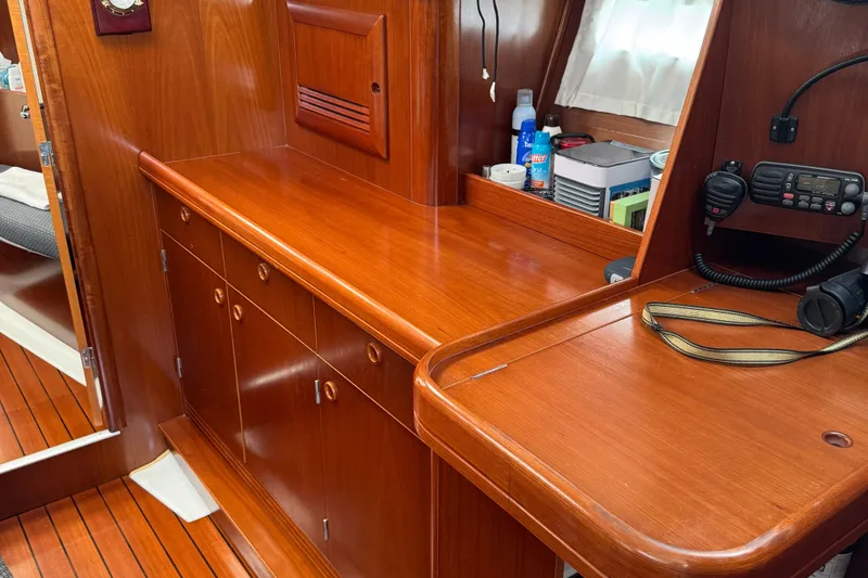 Slide: The Image of Interior of 2003 Beneteau 393 sailboat with wooden cabinetry and navigation equipment. - 11