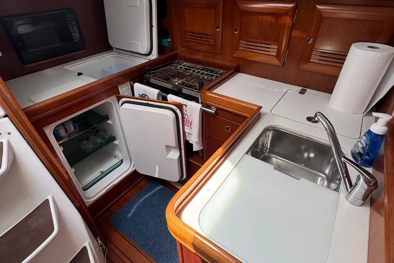 Slide: The Image of Galley kitchen in 2003 Beneteau 393 yacht with sink, fridge, and stove. - 13