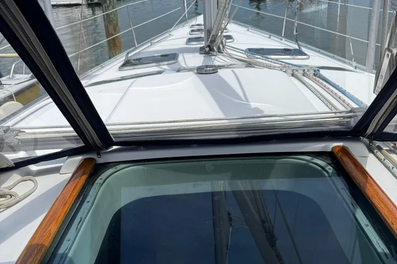 Slide: The Image of Deck view of a 2003 Beneteau 393 sailboat, featuring rigging and clear skies. - 15