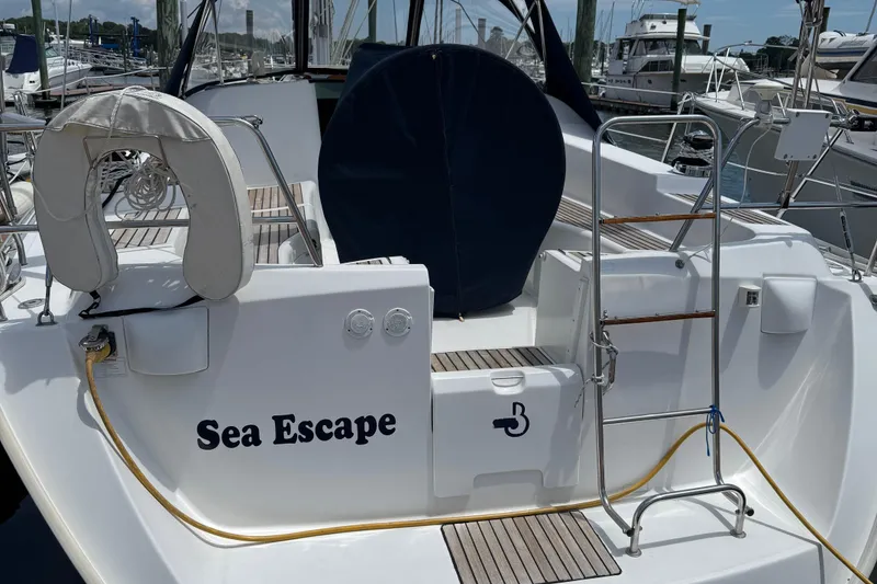 Slide: The Image of 2003 Beneteau 393 sailboat "Sea Escape" docked, featuring a life preserver and ladder. - 4