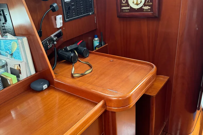 Slide: The Image of Navigation station on 2003 Beneteau 393 yacht with wooden finish, binoculars, and control panel. - 9