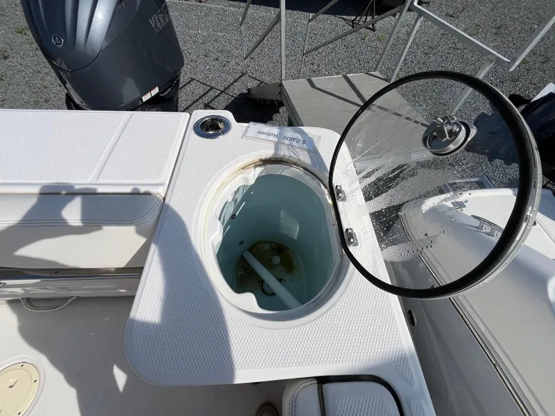 Slide: The Image of 2024 Robalo R230 Center Console boat interior with open storage compartments and seating. - 4
